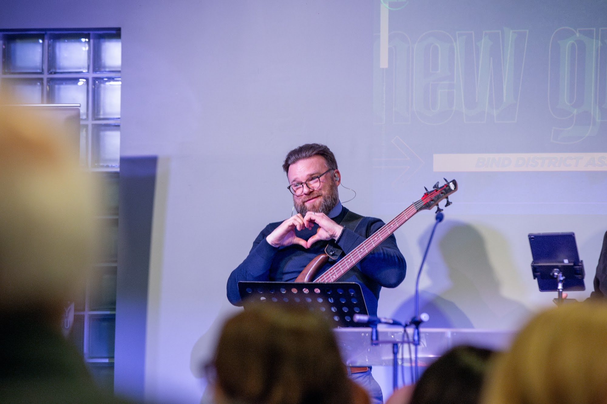 A bass player making a heart shape with his hands